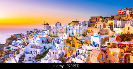 Vue panoramique de la ville d'Oia, Santorin, Grèce au coucher du soleil. Célèbre et traditionnel des maisons blanches et des églises aux dômes bleus sur la caldeira, la mer Égée. Banque D'Images