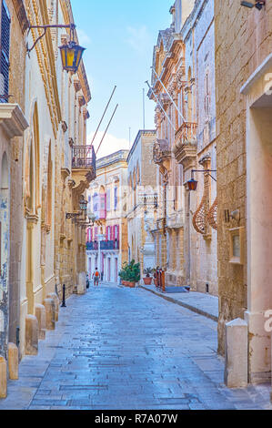 La rue étroite mène le long de lignes de vieux édifices en pierre médiévale de Mdina, Malte dans la forteresse Banque D'Images