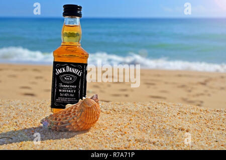 Faro, Portugal - 12/10/2018 : Petite bouteille Jack Daniels Whiskey dans l'océan des coquillages sur le sable. Parti alcoolique dans un style nautique sur le shor Banque D'Images