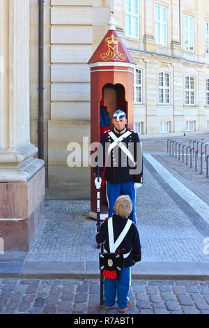 Une vie Royal Guard à la monarchie danoise de service devant sa guérite et petit garçon à l'extérieur le Palais d'Amalienborg à Copenhague, Danemark Banque D'Images