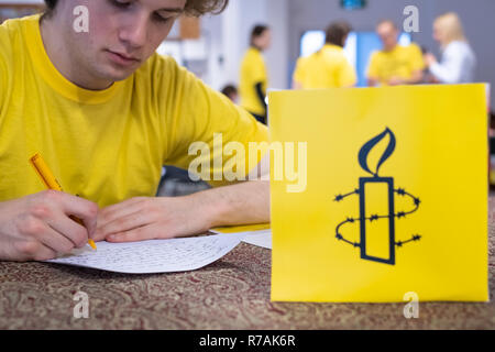 Varsovie, Pologne. 8 Décembre, 2018. 'Écrire pour l'homme" est le plus grand événement de l'homme, organisée par Amnesty International. Des millions de lettres seront envoyées à ceux, dont les droits de l'homme sont attaqués. Ce jeune militant s'écrit la lettre suivante, pas le dernier à ce jour. Robert Pastryk / Alamy Live News Banque D'Images