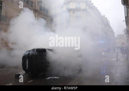 Paris, France. 8e Dec 2018. Vu les pompiers éteindre un véhicule en feu près de Champs-élysées, autour de l'Arc De Triomphe pendant un gilet jaune manifestation à Paris. 4ème week-end de manifestations anti gouvernement jaune à Paris avec des milliers de manifestants saccageant les voitures, les magasins ou les biens publics, la mise en place des barrages routiers autour de Champs Elysées et l'Arc de Triomphe. La force de police ont utilisé des gaz lacrymogènes et ont fait plus d'un millier d'arrestations. Credit : SOPA/Alamy Images Limited Live News Banque D'Images