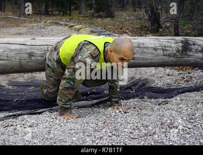 Le sergent de l'armée américaine. Luis Cruz, 597e Brigade, de transport et de sous-officiers de la SDDC 2017 ans, rampe sous un obstacle au cours de l'Endurance physique bien sûr partie de la SDDC 2017 Concours meilleur guerrier. Banque D'Images