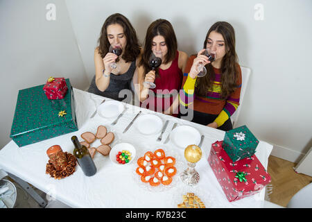 À partir de au-dessus du groupe de jeunes femmes de boire du vin tout en étant assis à table avec paniers-cadeaux et repas de fête Banque D'Images