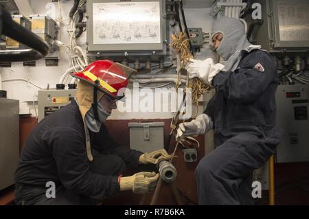 Mer Méditerranée (6 mai 2017) Les systèmes de turbine à gaz (mécanique), pompier Krystian Kielb de Sterling Heights, Michigan, à gauche, et de l'électronique 3ème classe technicien Darrin Ngyuan patch un tuyau à bord de la classe Arleigh Burke destroyer lance-missiles USS Ross (DDG 71) au cours d'un exercice d'entraînement général quarts le 6 mai 2017. Ross, l'avant-déployé à Rota, Espagne, mène des opérations navales dans la sixième flotte américaine zone d'opérations à l'appui de la sécurité nationale des États-Unis en Europe et en Afrique. Banque D'Images