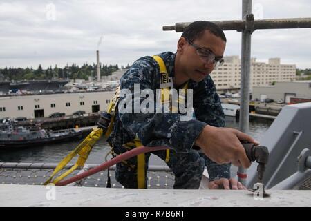 BREMERTON, Washington (8 mai 2017) l'Aviation maître de Manœuvre (manutention) 3e classe Kyle Vowell, d'Atlanta, sands nul un article de l'USS JOHN C. STENNIS (CVN 74) envol pour contrôler la corrosion avec une ponceuse à main. John C. Stennis mène une disponibilité progressive prévue (PIA) au chantier naval de Puget Sound et l'Installation de maintenance de niveau intermédiaire, au cours de laquelle le navire est soumis à des activités de maintenance et de mise à niveau. Banque D'Images