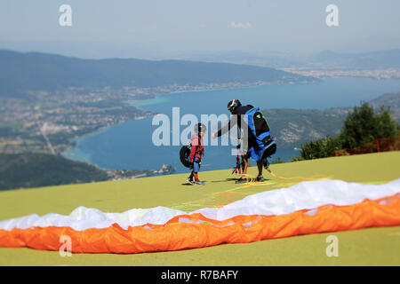 Un pilote et son passager tandem prépare à voler depuis le Col de la Forclaz le décollage avec le lac d'Annecy à l'arrière-plan Banque D'Images