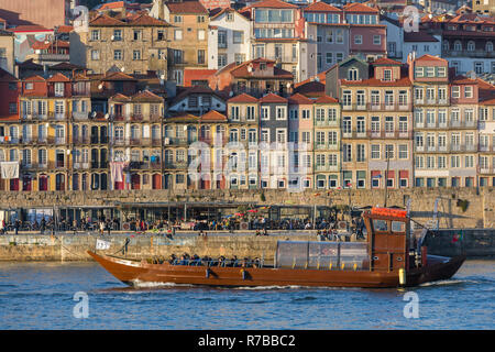 Porto, Portugal, le 19 janvier 2018 : un bateau de croisière en passant par de belles maisons colorées sur les bords de la rivière Douro, dans la vieille ville de Porto, Portugal Banque D'Images