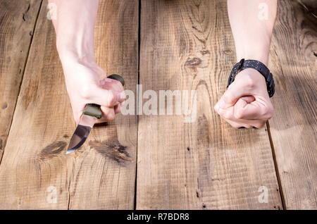 Couteau à lame fixe en main. Le couteau et le poing. De point de vue. Banque D'Images