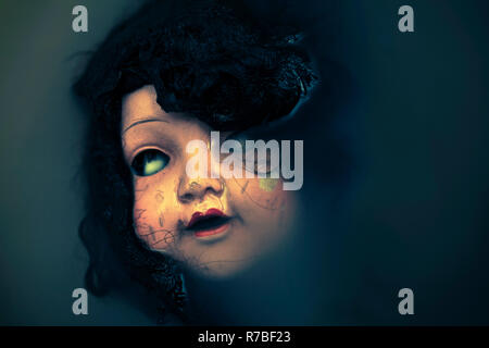 Creepy doll face dans l'eau sombre sale Banque D'Images