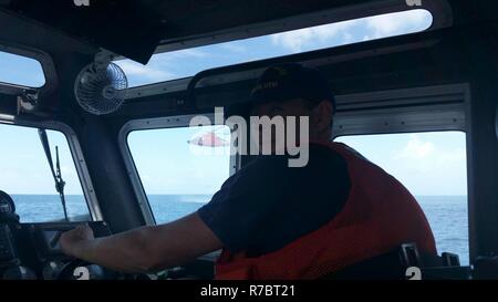 U.S. Coast Guard maîtres mate 2e classe Jack Trahan dirige le bateau tout en fournissant une patrouille de sécurité au cours de la formation conjointe entre le 53e Escadron de reconnaissance de la météo et de la Garde côtière des États-Unis au cours de la survie de l'eau partie de survie, évasion, résistance et fuite (SERF) une formation d'appoint dans les eaux côtières de la Sainte Croix, îles Vierges américaines, Mai 8,2017. Banque D'Images