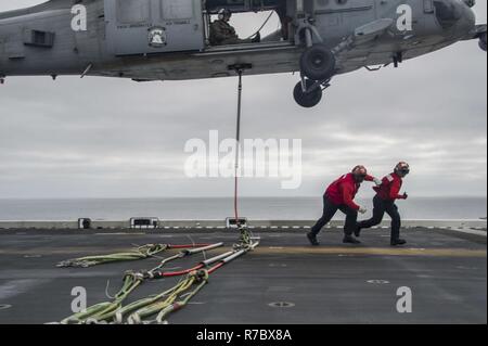 Océan Pacifique (12 mai 2017) l'Aviation 2e classe Ordnanceman Alex George, originaire de Shreveport, Louisiane, et d'aviation aviateur Ordnanceman Jailene Benitez, originaire d'Aurora, Illinois, courir à une zone de sécurité après avoir accroché un câble au bas d'un MH-60 Seahawk, affecté à la "Jokers" de l'Escadron d'hélicoptères de combat de la Mer 23, à bord du navire d'assaut amphibie USS America (LHA 6). Plus de 1 800 marins et 2 600 Marines américains affectés à l'Amérique du groupe amphibie (ARG) et la 15e MEU sont actuellement à l'unité de formation Composite (Exercice COMPTUEX) au large de la côte méridionale de Cali Banque D'Images