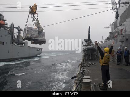 Océan Pacifique (Mai 13, 2017) Maître de Manœuvre 3 Classe Kamren en coton, de Porter, Texas, signale le navire de munitions et de marchandises sèches USNS Wally Schirra (T-AKE 8) à partir de la classe Arleigh Burke destroyer lance-missiles USS Michael Murphy (DDG 112) au cours d'un ravitaillement en mer dans l'ouest de l'océan Pacifique. La Marine américaine a patrouillé les Indo-Asia-Pacifique couramment pour plus de 70 ans la promotion de la paix et la sécurité régionales. Banque D'Images