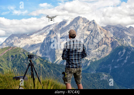 Drone pilote décolle d'un drone dans les Dolomites de la Marmolada en arrière-plan Banque D'Images