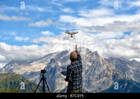 Drone pilote décolle d'un drone dans les Dolomites de la Marmolada en arrière-plan Banque D'Images