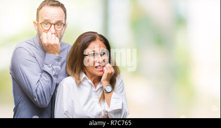 L'âge moyen hispanic couple amoureux portant des lunettes sur fond isolé à souligné et nerveux avec les mains sur la bouche de mordre les ongles. L'anxiété pro Banque D'Images