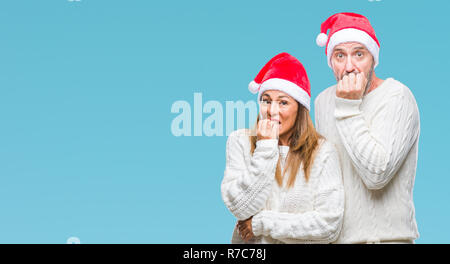 L'âge moyen hispanic couple wearing christmas hat sur fond isolé à souligné et nerveux avec les mains sur la bouche de mordre les ongles. Problèmes d'anxiété Banque D'Images
