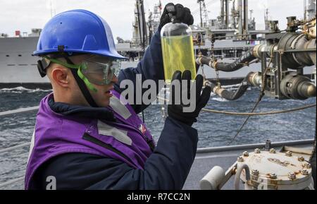 Pacifique occidental (13 mai 2017) Dommage Controlman 2e classe Luis Romero, de San Francisco, mène un test clair et lumineux sur le carburant obtenu à partir de la Henry J. Kaiser-classe en cours reconstitution oiler Marshalltown USNS (T-AO 204) au cours d'un ravitaillement en mer à bord de la classe Arleigh Burke destroyer lance-missiles USS Wayne E. Meyer (DDG 108). La Marine américaine a patrouillé les Indo-Asia régulièrement du Pacifique pendant plus de 70 ans la promotion de la paix et la sécurité régionales. Banque D'Images