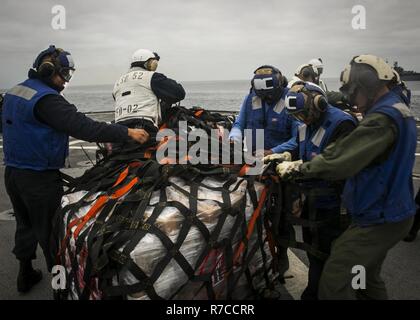 Océan Pacifique - Marines à combattre, le 15 bataillon de logistique Logistique Élément de combat de la 15e Marine Expeditionary Unit, affectés à la lutte contre les marins et du fret avec le service du pont, USS Pearl Harbor (LSD 52) enlever les sangles des rations alimentaires livrés au navire de ravitaillement vertical une mission au cours de l'exercice, l'unité de formation mixte le 11 mai 2017. La capacité de ravitaillement en mer donne le 15e MEU et l'Amérique latine le Groupe amphibie de la mobilité et la durabilité nécessaires pour maintenir un avantage sur les adversaires asymétriques. Au cours de la 15e, COMPTUEX MEU et AMAARG s'exer Banque D'Images