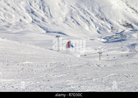 Skieur descend sur la pente de ski enneigées en hiver soleil soir. Montagnes du Caucase, la Géorgie, la région Gudauri. Banque D'Images