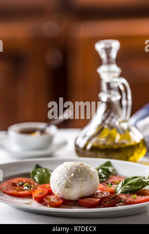 Salade Caprese tomates mozzarella à l'huile d'olive au basilic une d'épices. Banque D'Images