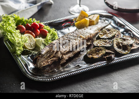 Poisson grillé sur lave avec des produits frais et de légumes grillés au barbecue. Banque D'Images