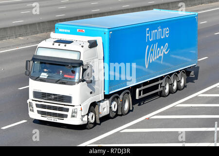 Le VHG blanc camion mastodonte truck driver & mobilier bleu Village chaîne d'articulé remorque Transport en voiture sur autoroute England UK Banque D'Images