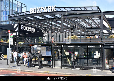 Scène de rue à Londres les gens attendre au bus des transports publics s'arrêtent à Boxpark restauration et commerce de détail construit à partir de conteneurs d'expédition de l'Angleterre East Croydon UK Banque D'Images