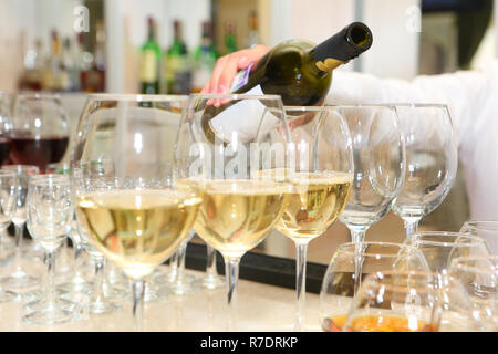 Waiter pouring wine in glasses Banque D'Images