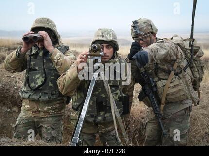 Le sergent de l'armée américaine. Sanchez affecté à un peloton, Compagnie Cobra rouge, 2e Bataillon, 8e régiment de cavalerie, 1st Armored Brigade Combat Team, 1re Division de cavalerie et soldats géorgiens examiner la gamme pendant une multinationale combined arms fire live event à l'appui de la préparation de la défense de la Géorgie au programme d'entraînement de Vaziani en Géorgie, 5 décembre 2018. Le GDRP est un programme conjoint de l'armée américaine qui conseille, d'encadrer et de former le personnel et les commandants de la Géorgie en vue d'améliorer la préparation au combat. Banque D'Images