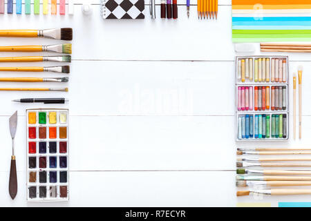 Outils de création d'un bureau avec fournitures de dessin peinture, pinceaux peintures colorées craies crayons et accessoires pour l'école d'art sur bois blanc ta Banque D'Images