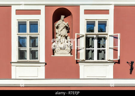 Deux fenêtres blanches rectangulaire sur l'arrière-plan d'un mur rose avec une sculpture situé entre eux dans une niche. Banque D'Images