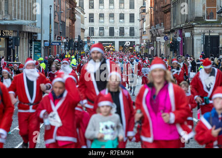 Plus de 8000 personnes prennent part à la Glasgow Santa Dash 2018. Porteur est parti de George Square à 10h. Les routes sont fermées dans le centre-ville comme une mer de Santa's font leur chemin le long de la route de 5 km. L'événement de bienfaisance recueille des fonds pour la charité. Cancer Beatson Banque D'Images