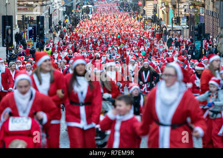 Plus de 8000 personnes prennent part à la Glasgow Santa Dash 2018. Porteur est parti de George Square à 10h. Les routes sont fermées dans le centre-ville comme une mer de Santa's font leur chemin le long de la route de 5 km. L'événement de bienfaisance recueille des fonds pour la charité. Cancer Beatson Banque D'Images