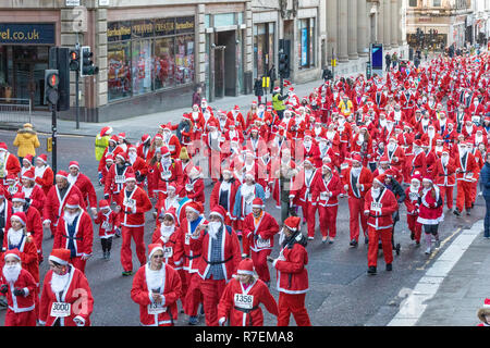 Plus de 8000 personnes prennent part à la Glasgow Santa Dash 2018. Porteur est parti de George Square à 10h. Les routes sont fermées dans le centre-ville comme une mer de Santa's font leur chemin le long de la route de 5 km. L'événement de bienfaisance recueille des fonds pour la charité. Cancer Beatson Banque D'Images