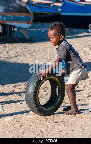 L'enfant malgache jouant avec un pneu usagé, Morondava, la province de Toliara, Madagascar Banque D'Images