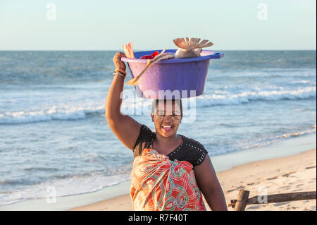 Femme Malgache transport du poisson dans une baignoire sur la tête, Morondava, la province de Toliara, Madagascar Banque D'Images