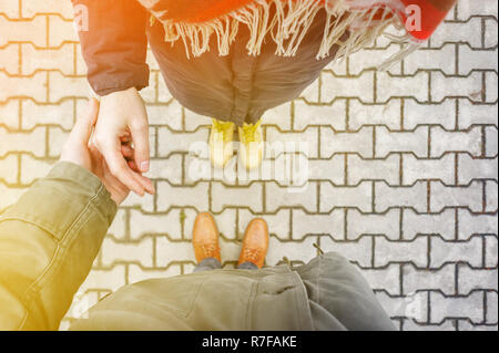 Vue à la première personne du couple holding hands. Couple d'amoureux se tenant la main lors de la marche au coucher du soleil. Concept d'excuses Banque D'Images