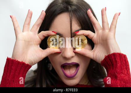 Heureux Succès Woman Holding Bitcoins devant ses yeux Banque D'Images