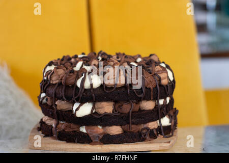 Mousse au chocolat avec des couches rempli de blanc, le lait et la mousse au chocolat noir sur fond jaune Banque D'Images