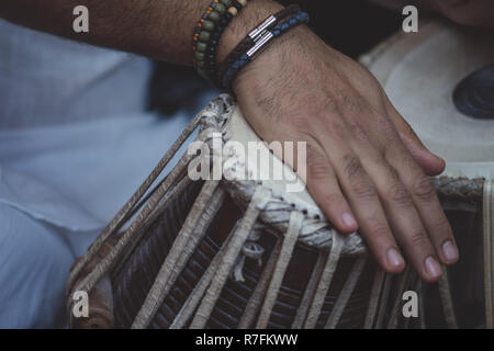 Image d'un man's hands (porter des perles) à jouer du tabla - instrument de percussion de la musique classique indienne - fond noir. Banque D'Images