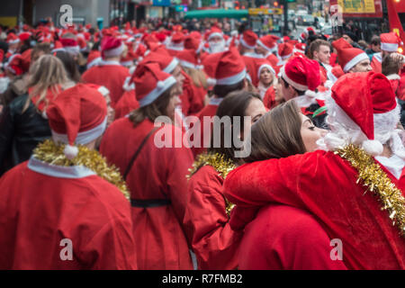 Londres, UK - Décembre 2018 : Hommes et femme, embrasser et s'étreindre l'autre tout en participant à un événement à thème SantaCon Banque D'Images