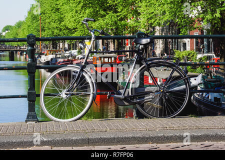 Vélo hollandais traditionnel garée sur un pont-canal à Amsterdam, Pays-Bas Banque D'Images