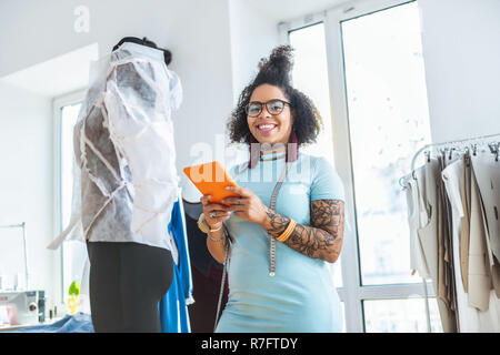 Smiling smiling woman wearing robe bleue et de dépenses à jour studio équipé Banque D'Images