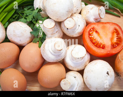 Gros plan du champignon avec des œufs sur une planche à découper sur fond blanc Banque D'Images