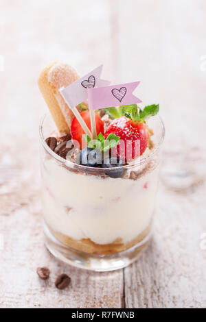 Tiramisu dessert italien fait maison avec des fraises, de menthe et de cacao dans des bocaux en verre, gros plan Banque D'Images