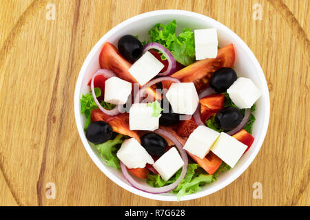 Salade grecque avec des légumes frais, fromage feta et olives noires sur un fond de bois. Vue d'en haut. Banque D'Images