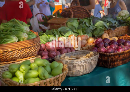 Une vérité des oignons, des pommes de terre parmi tant d'Anlong avec toute une gamme de verts, offrant de nombreuses options d'accompagnement. Les gens de l'arrière-plan sont des provisions Banque D'Images