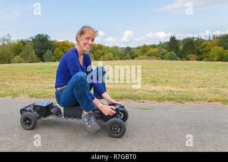 Dutch woman rides mountainboard électrique sur la nature en allemand Banque D'Images