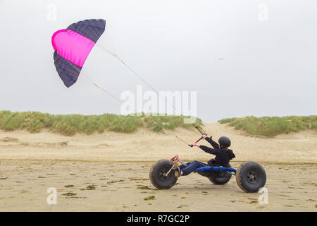 Dutch boy driving kite buggy kite avec flyer on beach Banque D'Images